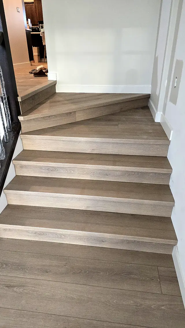 Staircase finished in light gray-beige plank flooring