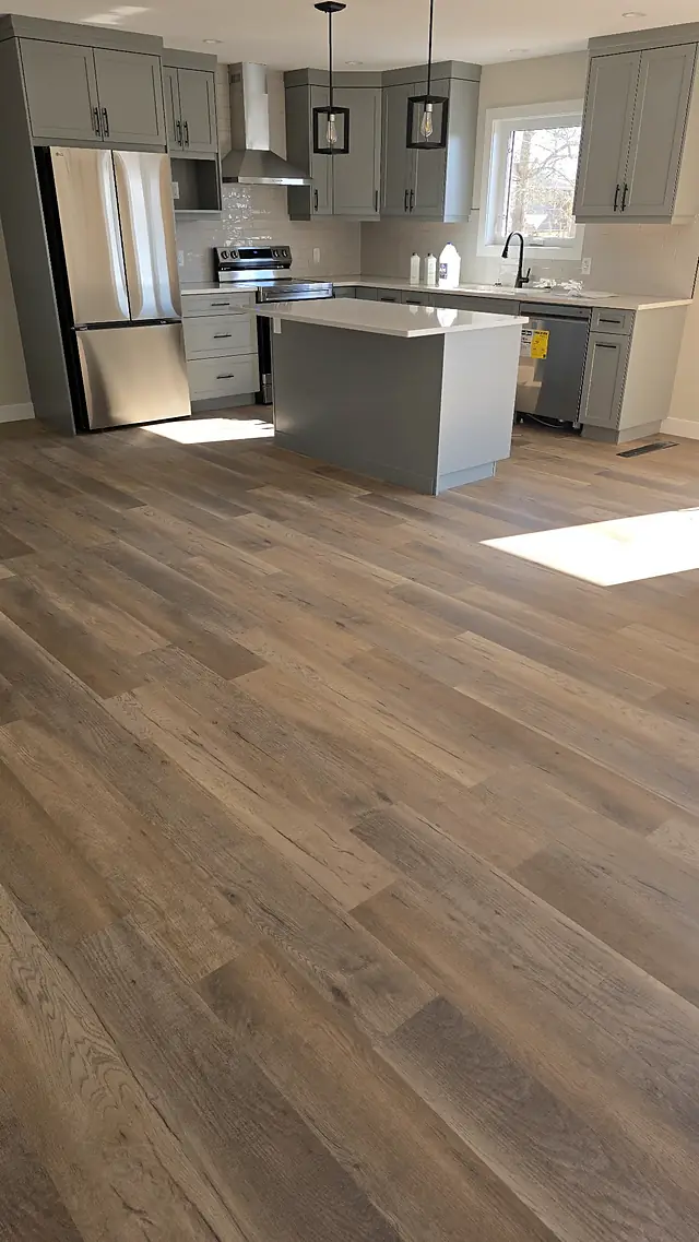Bright kitchen with gray cabinets and wide plank flooring